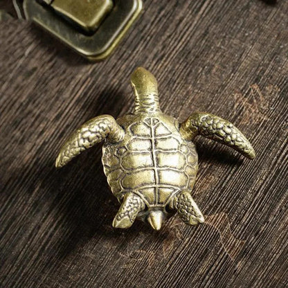 Bronze turtle figurine on a wooden surface