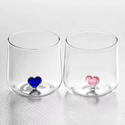 Two clear glasses with heart-shaped bottoms.