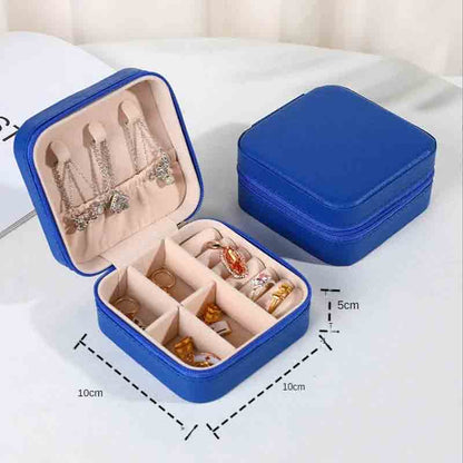 An open royal blue square jewelry box filled with various necklaces, earrings, and rings, with a closed matching box in the background, showing dimensions of 10cm x 10cm x 5cm.
