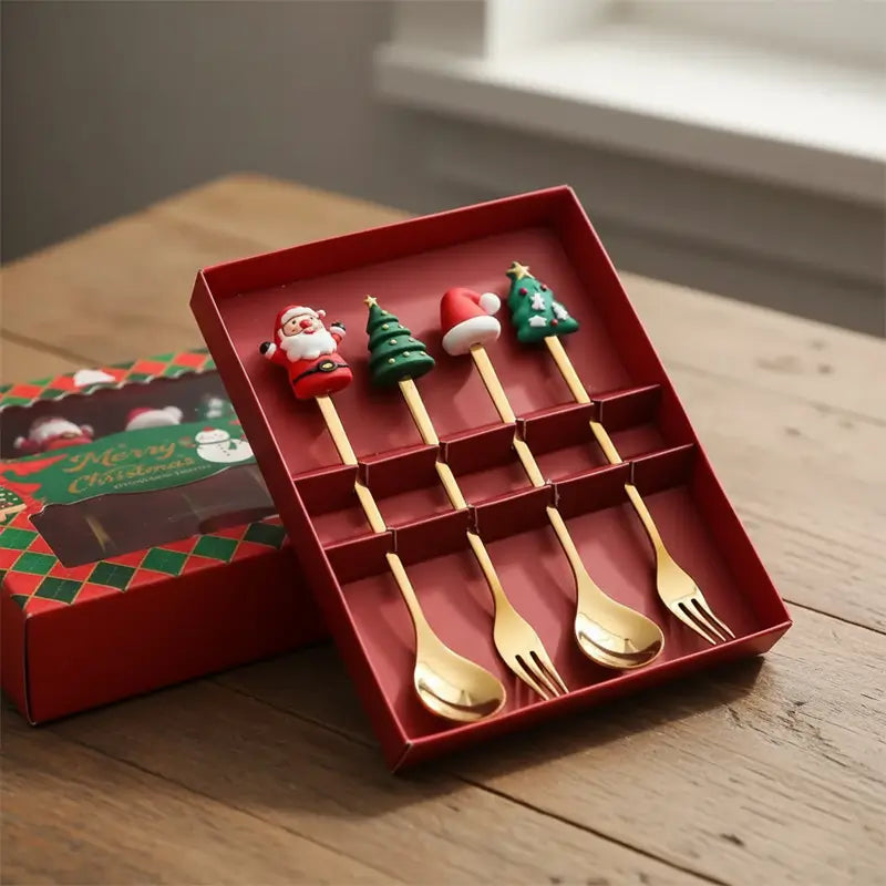 A red gift box holds four gold spoons and four gold forks, each with a different Christmas-themed handle.