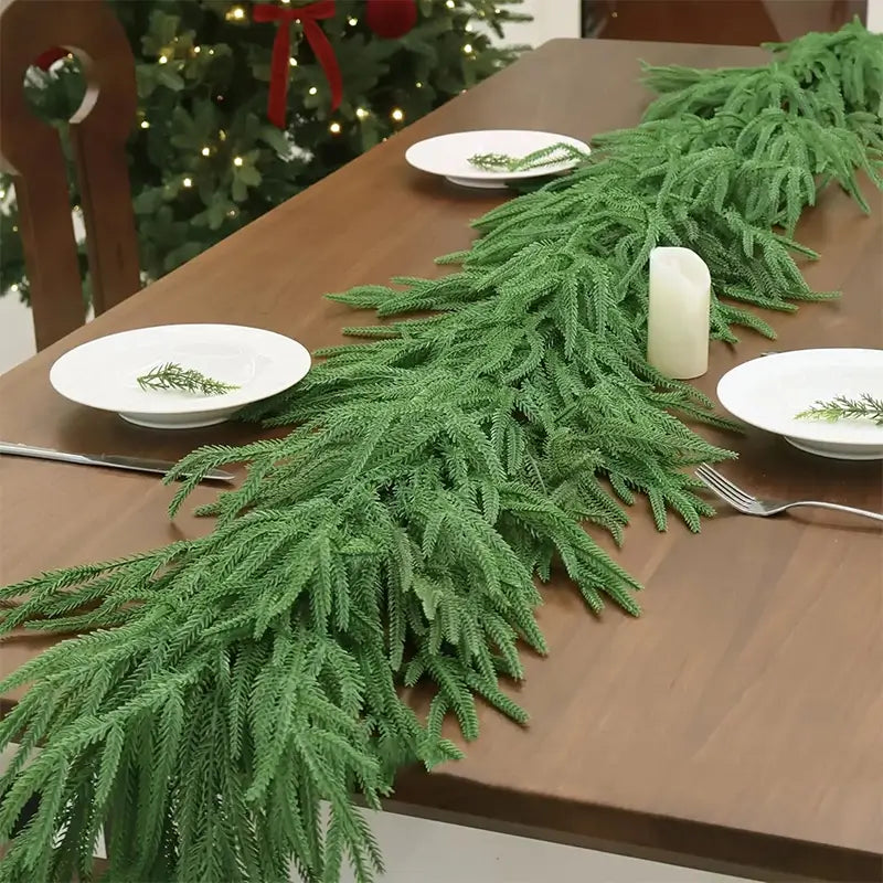 A green garland as a table runner with place settings.