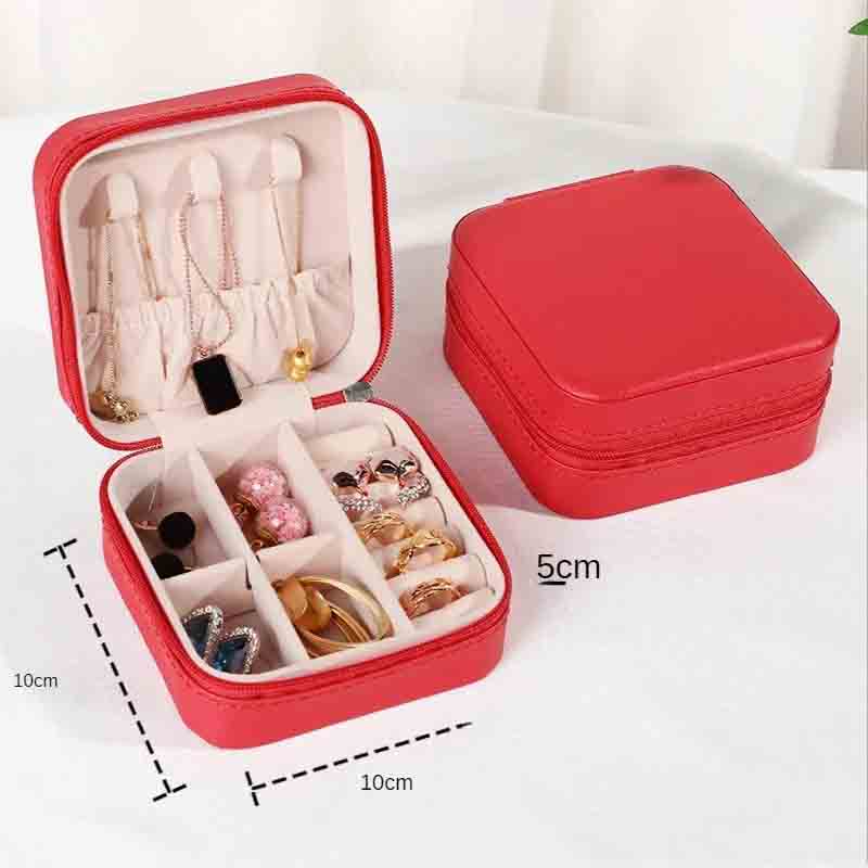 An open red square jewelry box filled with various necklaces, earrings, and rings, with a closed matching box in the background, showing dimensions of 10cm x 10cm x 5cm.