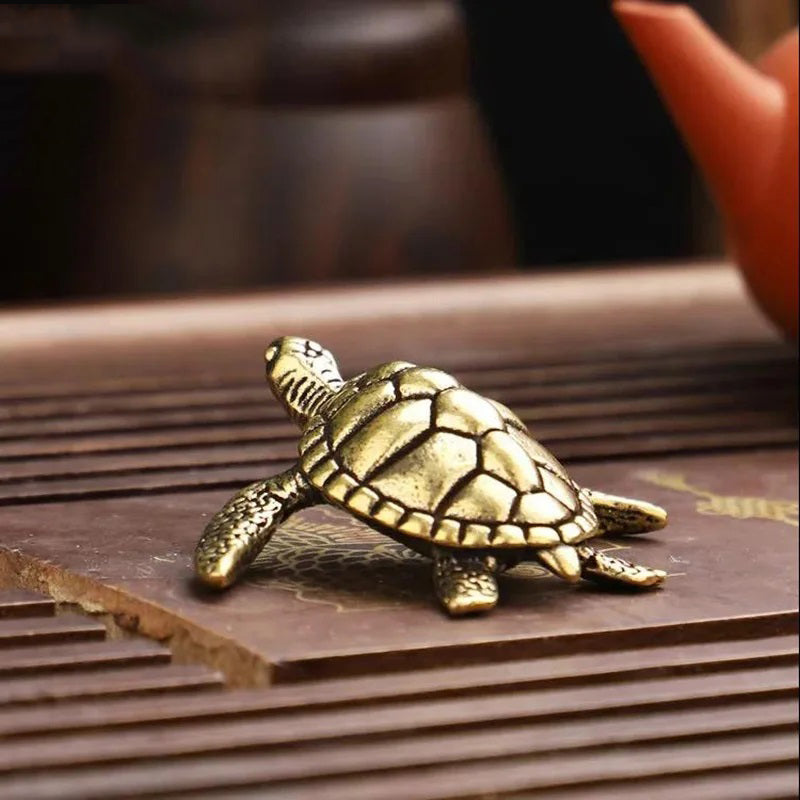 Bronze turtle figurine on a wooden surface