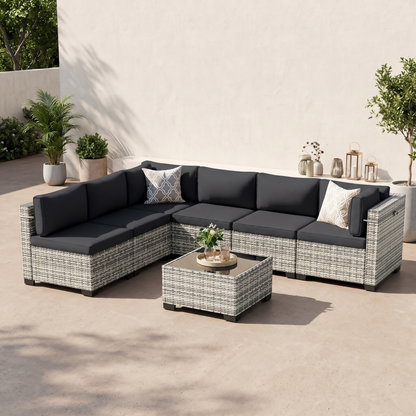 Black-cushion 7-piece modular wicker outdoor sectional with tempered-glass coffee table on a neutral patio