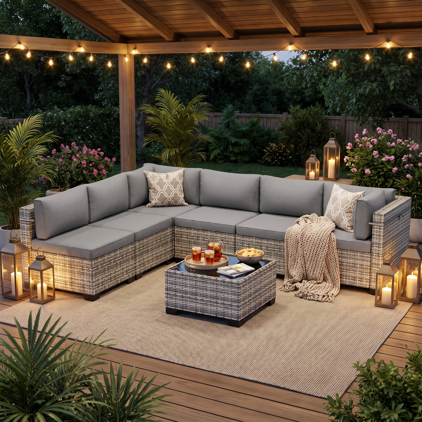 Gray-cushion 7-piece wicker outdoor sectional on a covered patio at dusk with string lights