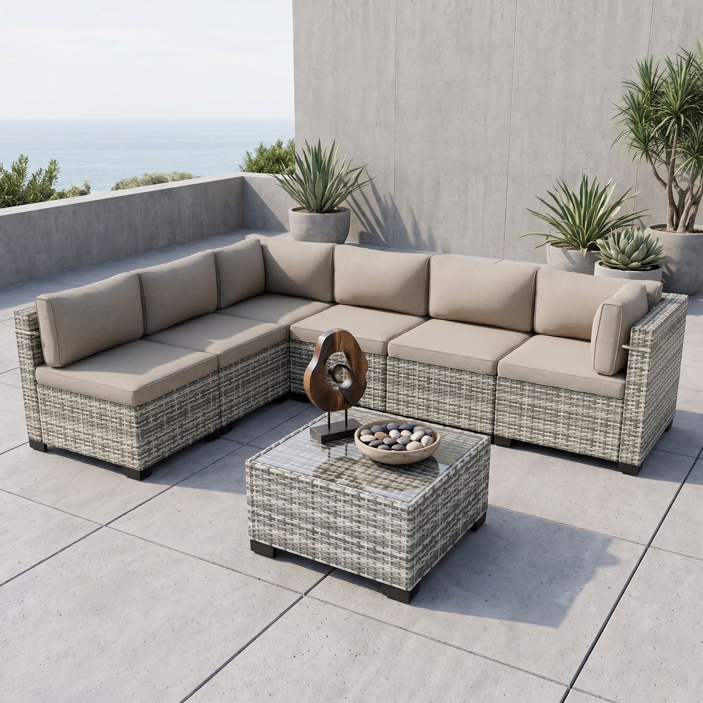 Gray-cushion 7-piece wicker outdoor sectional on a stone patio surrounded by greenery
