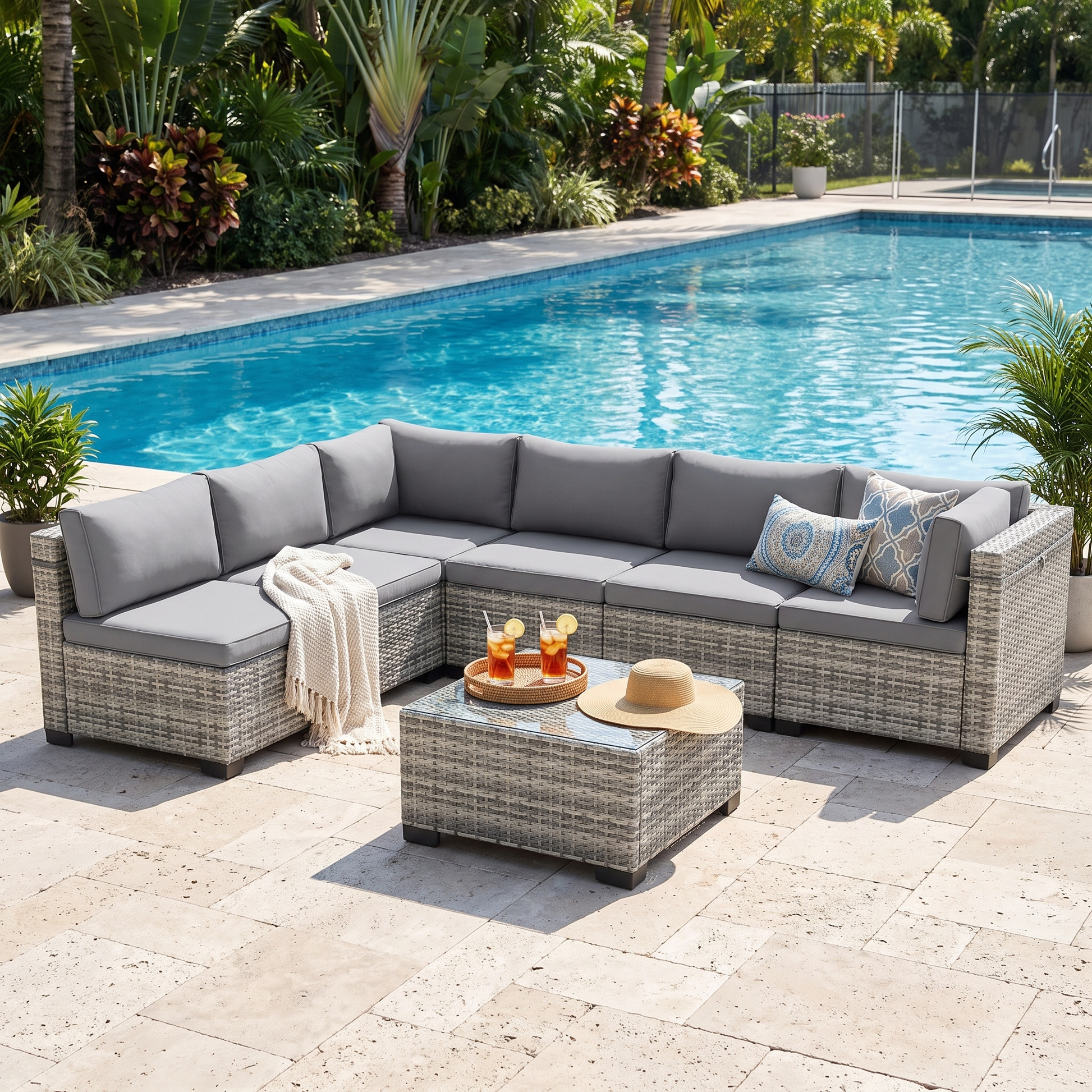 Taupe-cushion 7-piece wicker outdoor sectional arranged in a modular layout by a pool
