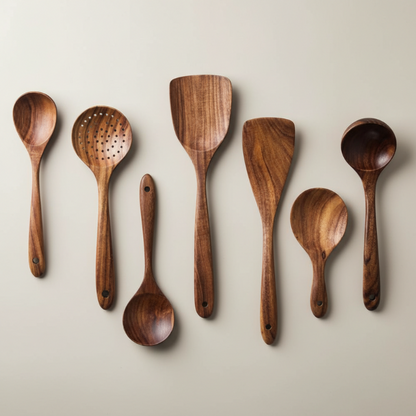 Set of wooden cooking utensils including spoons and spatulas on a beige background