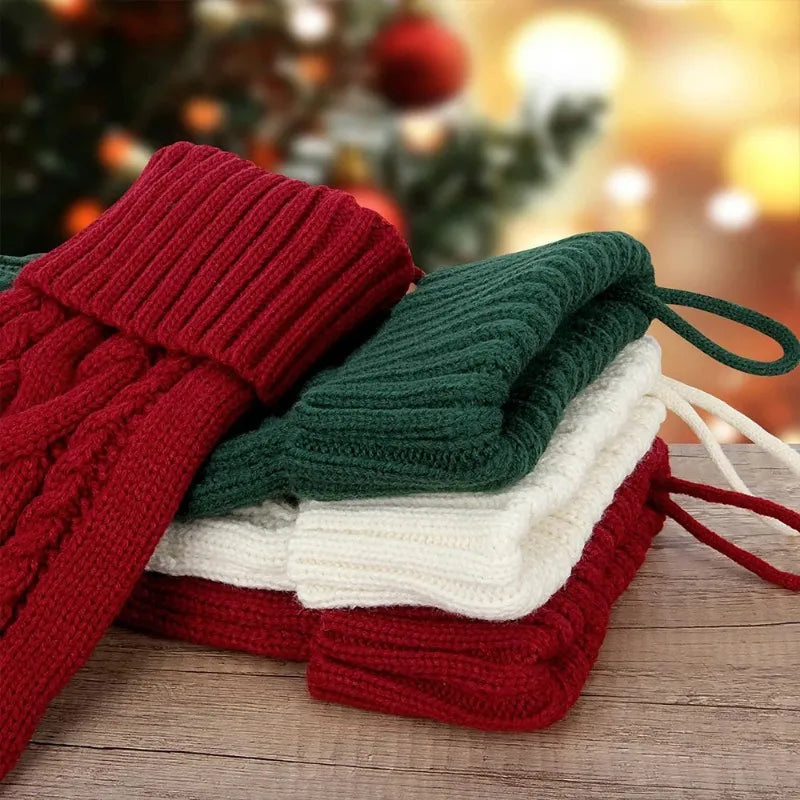 Folded red, green, and white knitted Christmas stockings on wood.