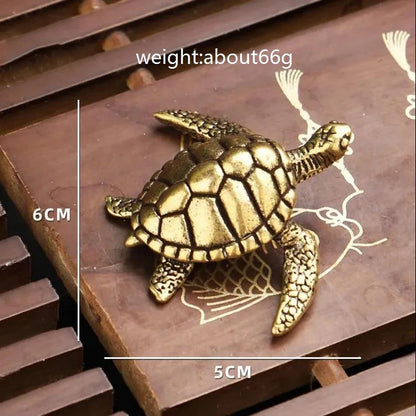 Gold turtle figurine on a decorative surface with measurements and weight information.