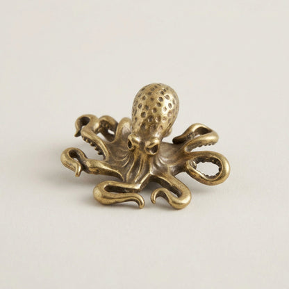Bronze octopus decorative item on a light beige background