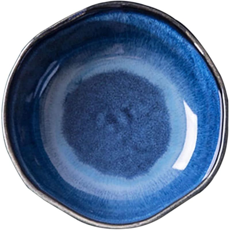 Top-down view of a handcrafted ceramic bowl featuring a rich blue gradient glaze with a slightly irregular shape and glossy finish.