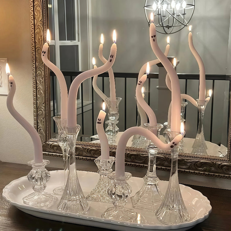 Decorative candle holder with ghost-shaped candles on a white tray in front of a mirror.
