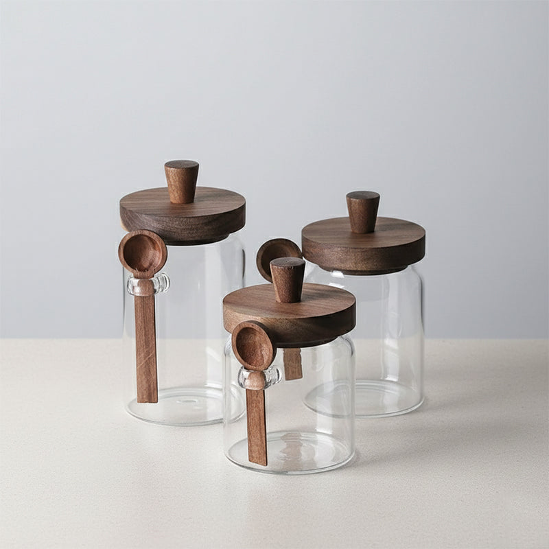 Set of glass jars with wooden lids on a light gray background