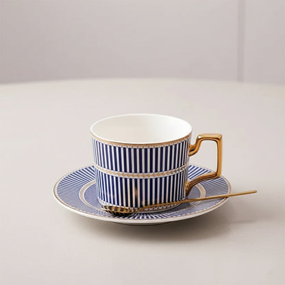 Navy striped cup and saucer with gold trim on a light gray background
