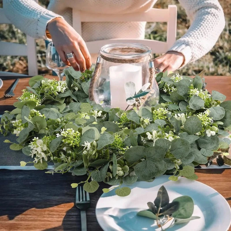 Artificial eucalyptus garland styled on a dining table, paired with candles to create a serene and calming atmosphere perfect for any meal.