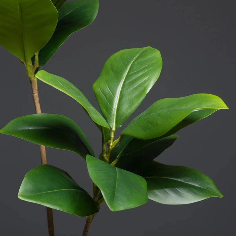 A close-up of the artificial magnolia tree’s lifelike green leaves, showcasing the detailed craftsmanship and realistic textures that make this tree an eye-catching decor piece.