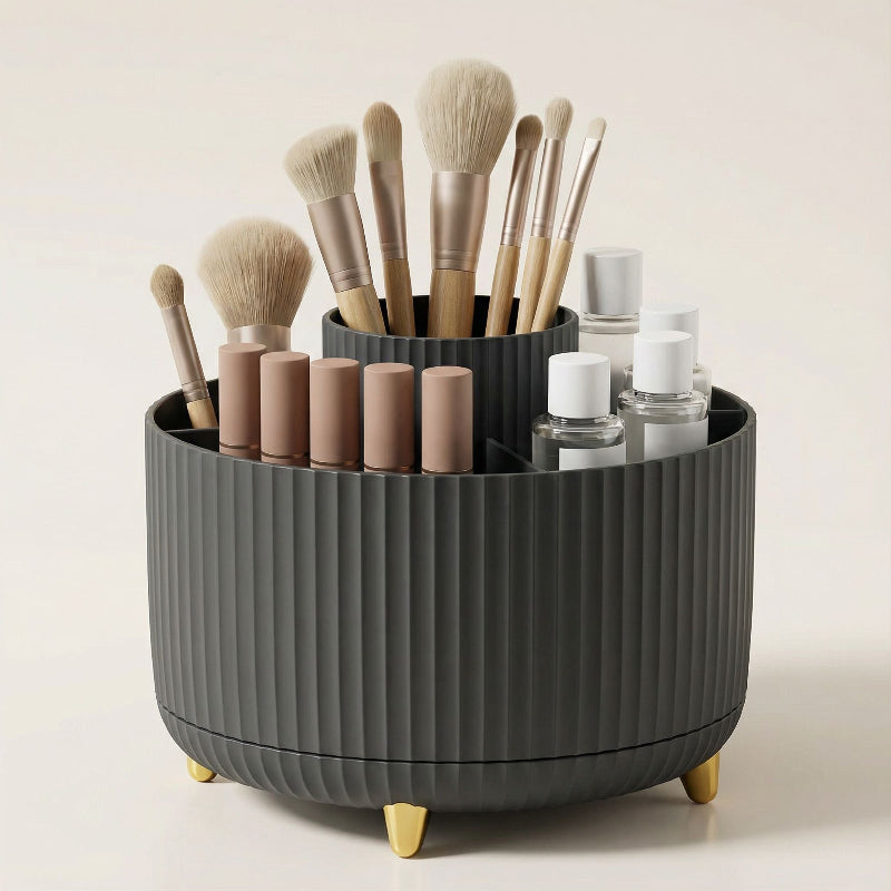 Black rotating makeup organizer with makeup brushes and cosmetics displayed on a vanity.