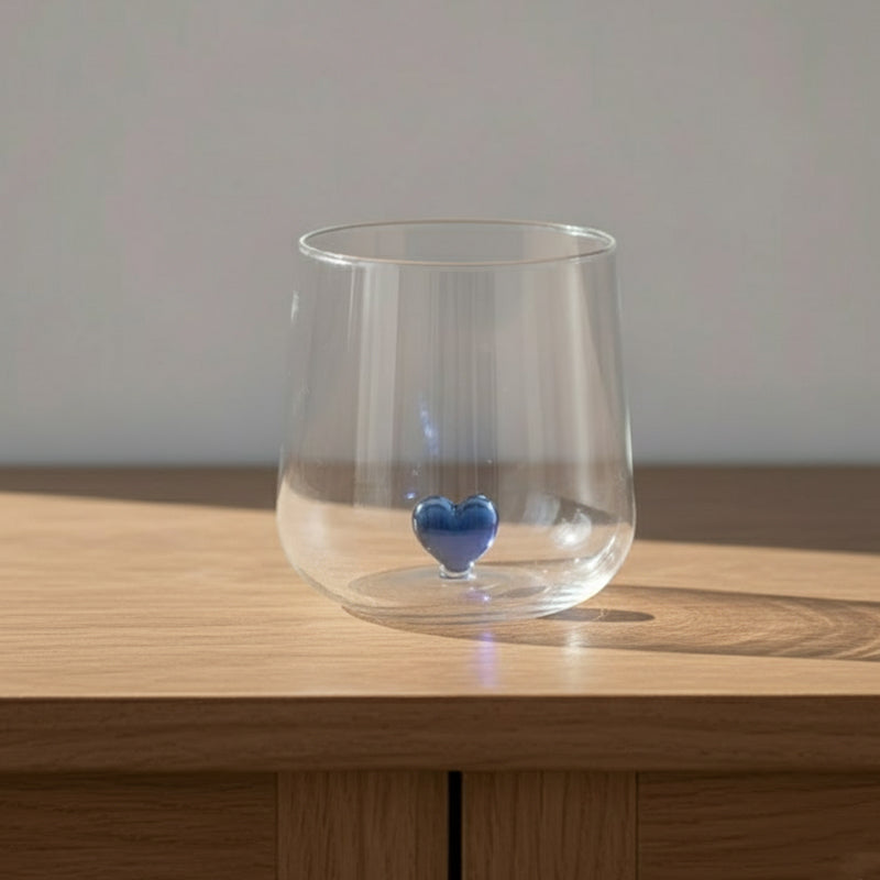 A clear glass with a blue heart at the bottom.