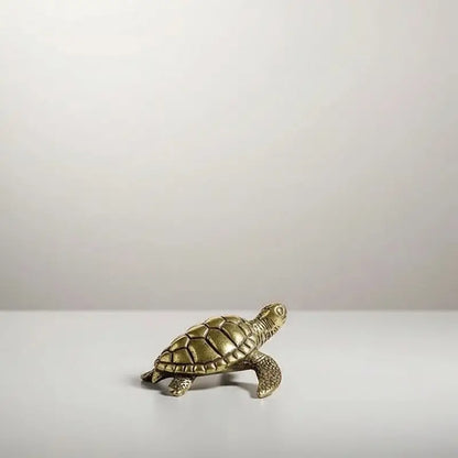 A small brass figurine of a turtle.