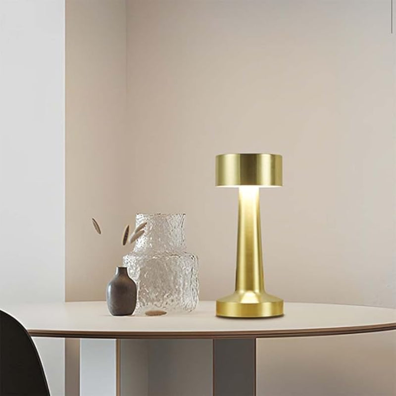 Portable cordless table lamp with a warm glow, ideal for creating cozy ambiance indoors or outdoors.