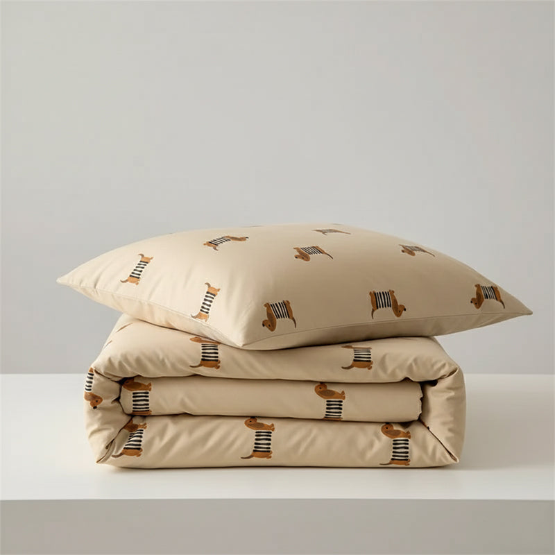 Duvet and pillowcase set in a tan color, printed with a repeating pattern of cartoon dachshunds wearing striped shirts.