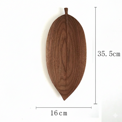 A wooden serving platter shaped like a dark brown, elongated leaf, with dimensions labeled as 35.5cm in height and 16cm in width.