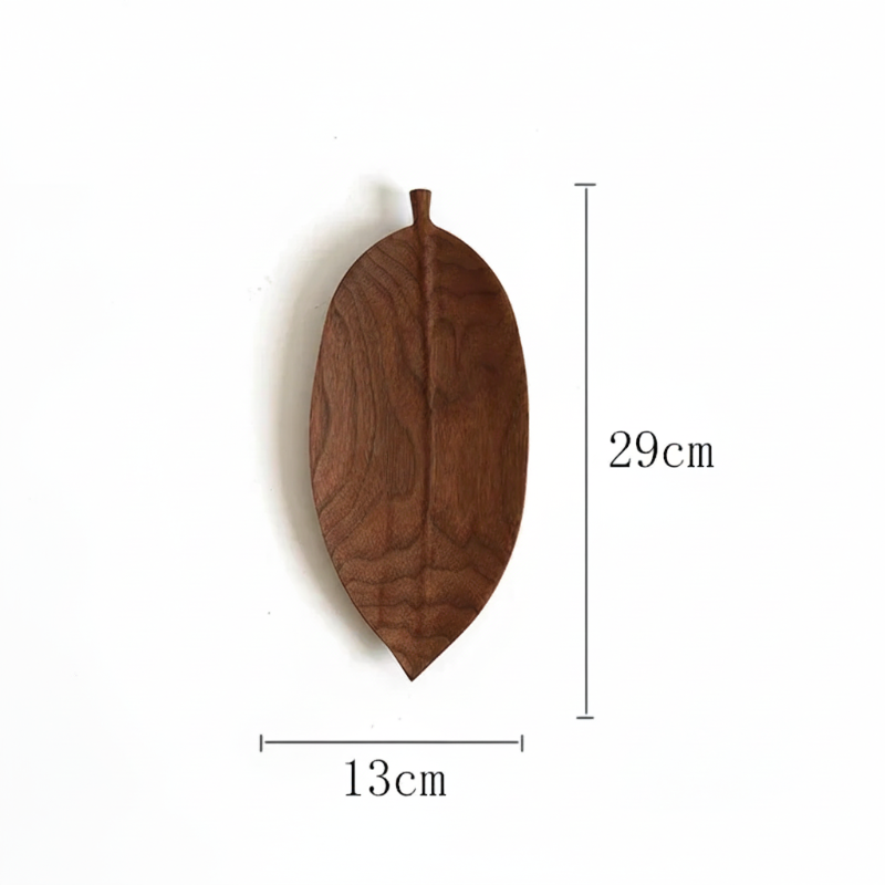 A wooden serving dish shaped like a dark brown, elongated leaf, with dimensions labeled as 29cm in height and 13cm in width.