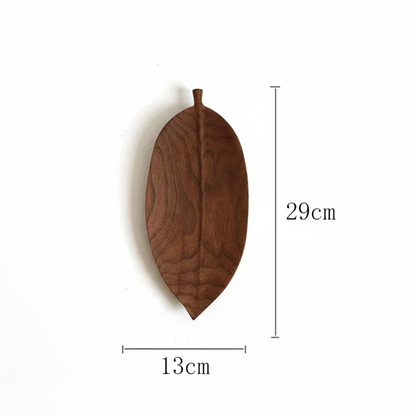 A wooden serving dish shaped like a dark brown, elongated leaf, with dimensions labeled as 29cm in height and 13cm in width.
