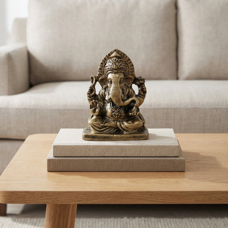 Bronze statue of a deity on a wooden table with a neutral background