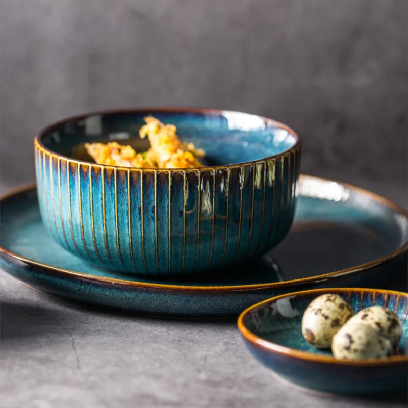 A set of blue ceramic dishes with a bowl full of food and two quail eggs in a smaller dish.