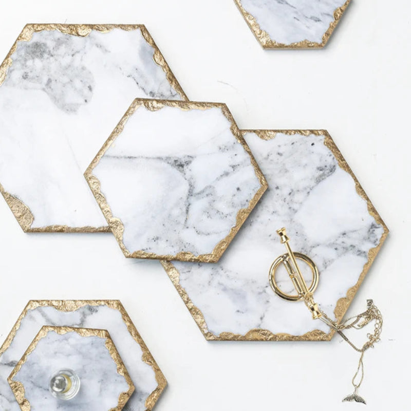 Hexagonal marble coasters with gold edges.