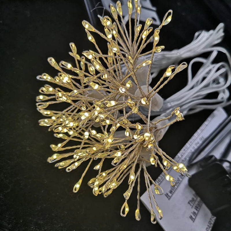 Close-up of dandelion-shaped string lights with warm glow.