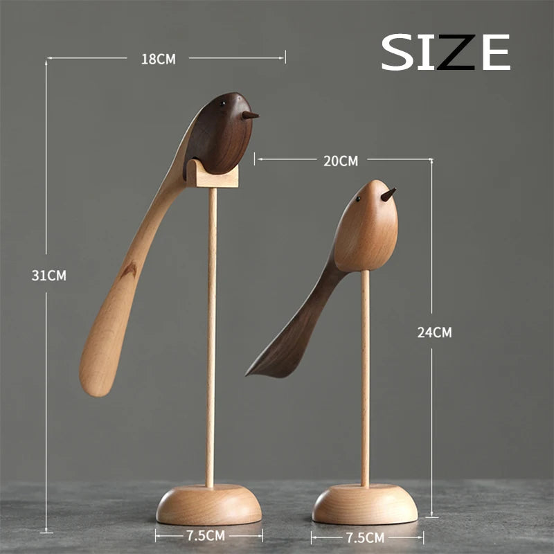 Product image of two decorative wooden bird figurines on stands, showing their dimensions: the taller bird is 31cm high by 18cm long, and the shorter is 24cm high by 20cm long, both with 7.5cm bases.