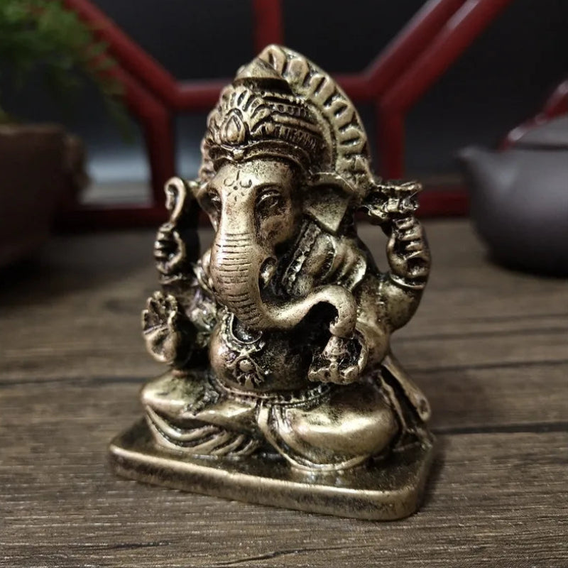 Bronze statue of a deity on a wooden surface with a blurred background