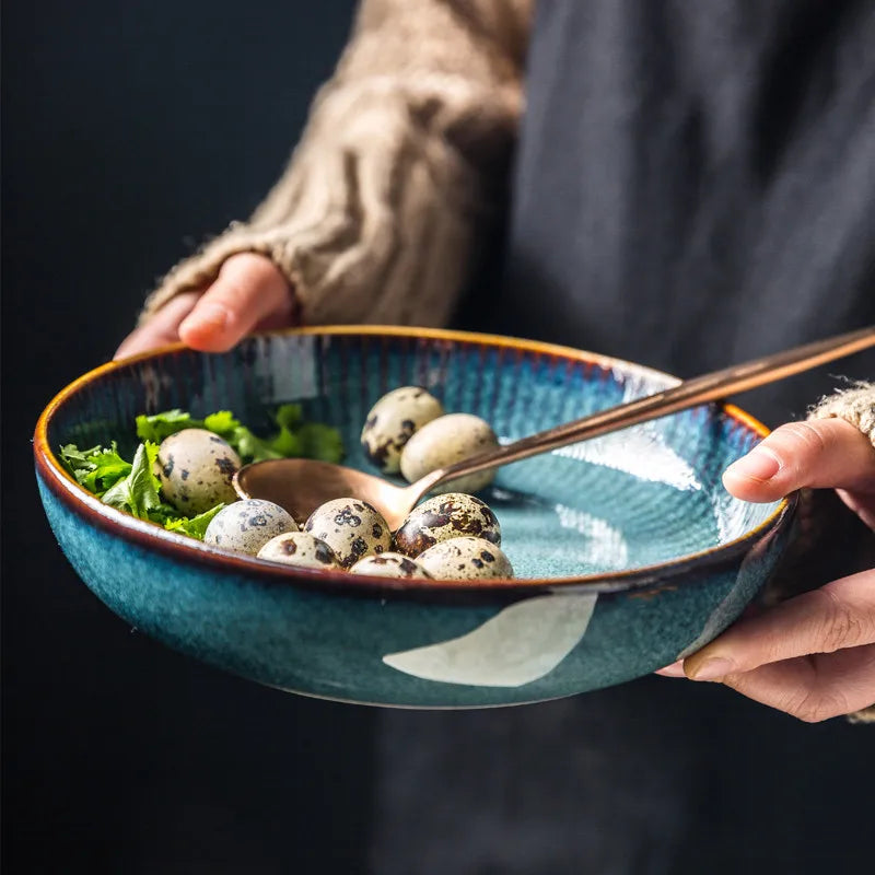 A person holding a blue ceramic bowl filled with quail eggs and greens.