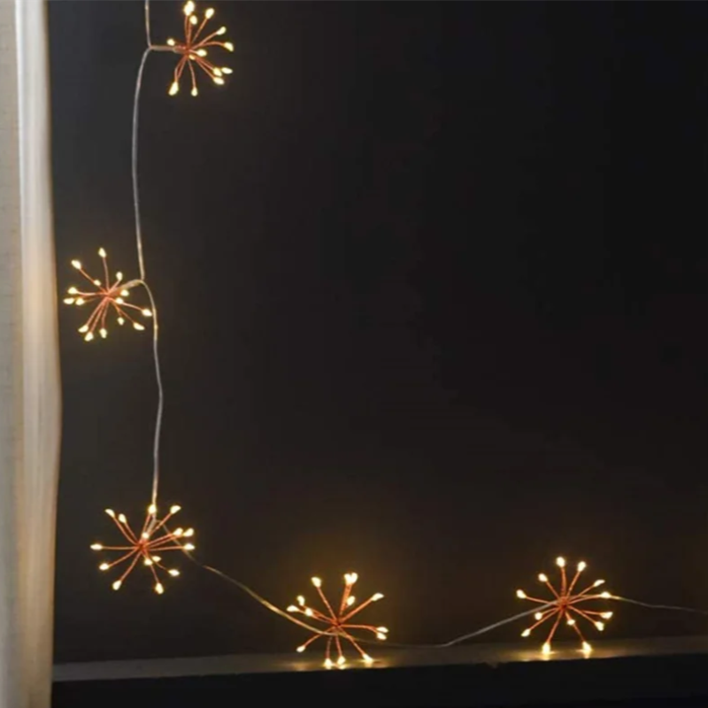 Dandelion-shaped string lights hanging vertically and horizontally against a dark background.