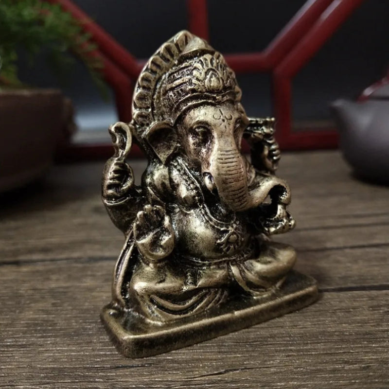 Bronze statue of a deity on a wooden surface with a blurred background