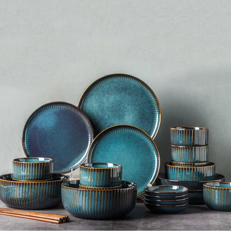 A full set of blue ceramic dinnerware, including various plates and bowls, with chopsticks.