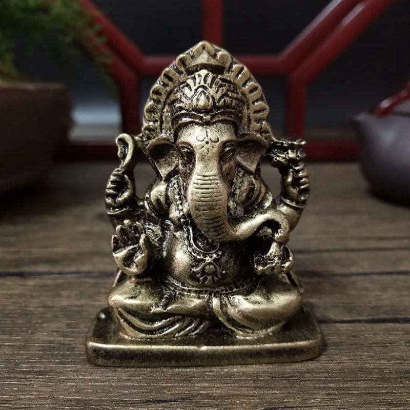 Bronze statue of a deity with elephant head on a wooden surface