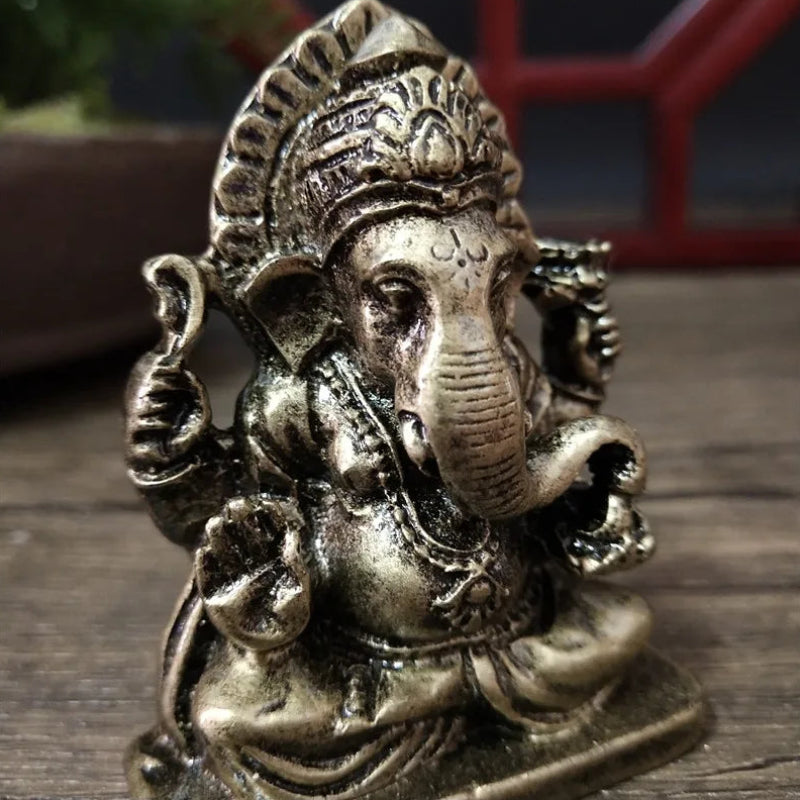 Bronze statue of a deity with a long nose on a wooden surface