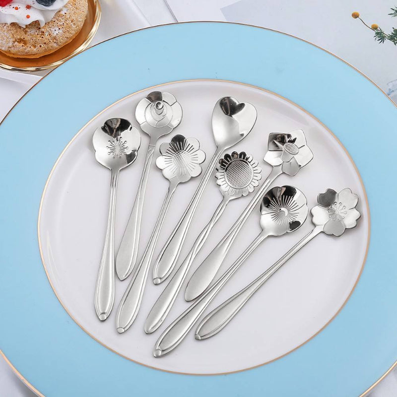 Silver flower spoons on a light blue and white plate.