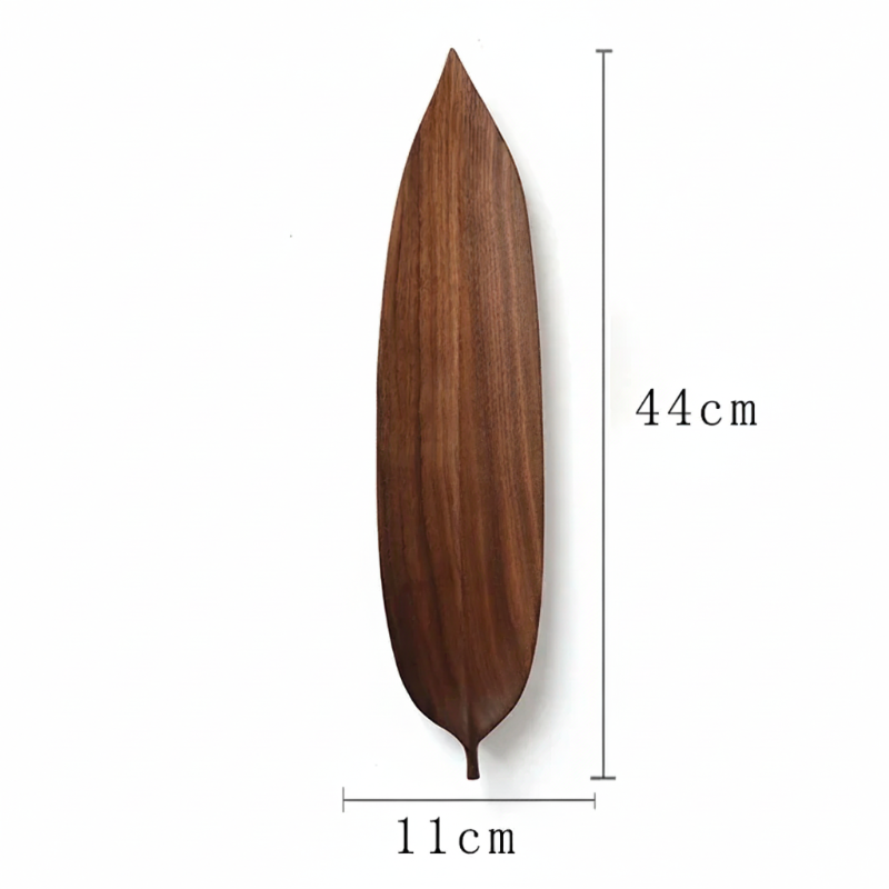 A long, narrow, dark brown wooden decorative serving board or dish shaped like a laurel or mango leaf, with dimensions marked as 44 CM in height and 11 CM in width, set against a plain white background.