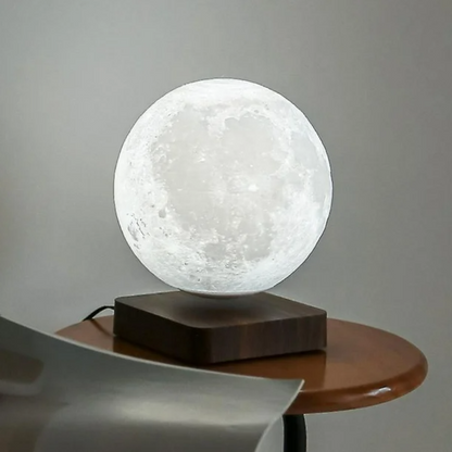 Levitating moon lamp illuminated in warm light, hovering over its wooden base.