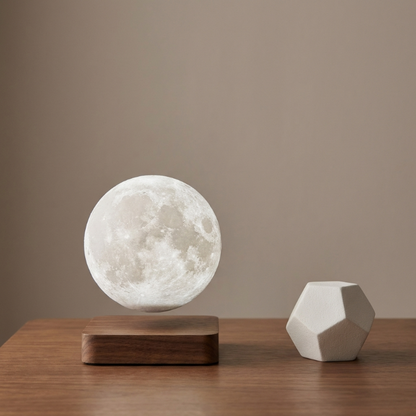 Levitating moon lamp on a wooden base with a geometric sculpture against a beige background