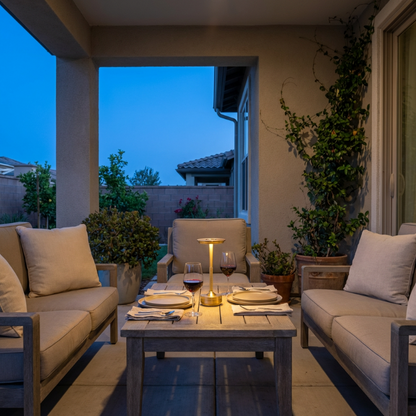 Evening outdoor patio setting with furniture and a candlelit table.