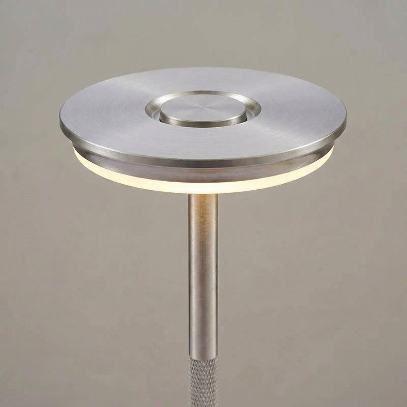 Modern floor lamp with metallic base and shade on a neutral background