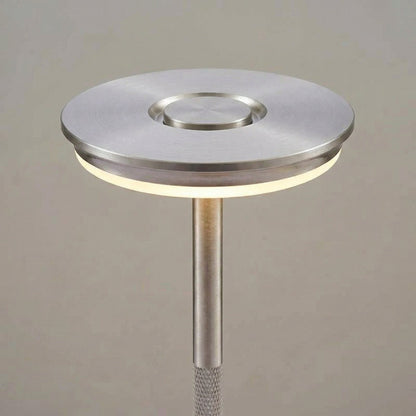 Modern floor lamp with metallic base and shade on a neutral background