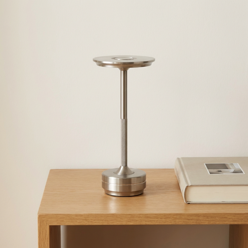 Silver lamp on a wooden table with a beige background