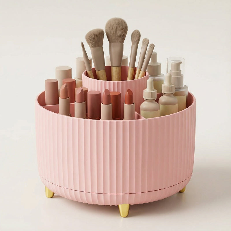 Pink rotating makeup organizer with makeup brushes and cosmetics on a vanity.